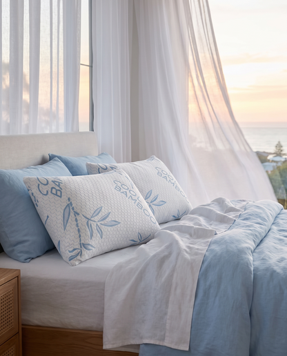 OMEO cooling bamboo pillows with blue leaf print on sky blue and white bedding in a bright coastal bedroom